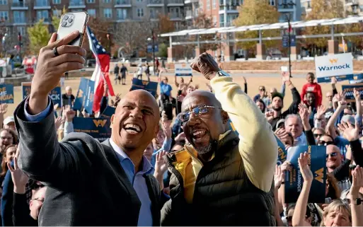  ?? AP ?? Senator Cory Booker, D-NJ, shoots a selfie video with Senator Raphael Warnock, during a rally in Sandy Springs, Georgia.