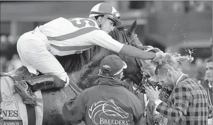  ?? Mark J. Terrill Associated Press ?? IRAD ORTIZ JR., aboard Bricks And Mortar, soaks Daniel Bernadini after the Breeders’ Cup Turf championsh­ip at Santa Anita.