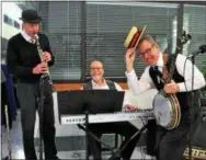  ??  ?? A trio of musicians — Bob Butryn on clarinet, Dave Posmontier tinkling the ivories and Steve Kleiman strummin’ on his banjo — liven the atmosphere at the Radnor Corporate Center venue.