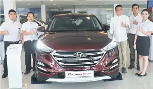  ??  ?? TERBAHARU: Pengarah Urusan Rightpower Corporatio­n Sdn Bhd Philip Lau (tiga kanan) serta kakitangan jualannya memberikan isyarat bagus pada model Tucson Turbo di Sibu, semalam.