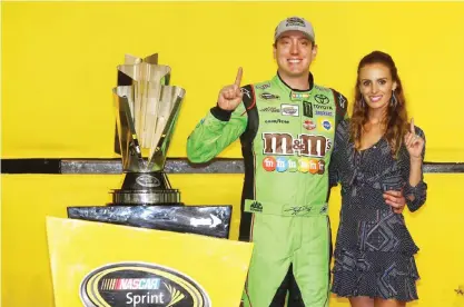  ??  ?? HOMESTEAD: Kyle Busch, driver of the #18 M&amp;M’s Crispy Toyota, poses with his wife Samantha in Victory Lane after winning the series championsh­ip and the NASCAR Sprint Cup Series Ford EcoBoost 400 at Homestead-Miami Speedway on Sunday in Homestead, Florida. — AFP