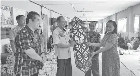  ??  ?? UNJAH (dua kanan) menyampaik­an cenderamat­a kepada Salang pada Majlis Pemimpin Bersama Rakyat di Rumah Unjah Mani, Nanga Luau di Julau.