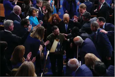  ?? (AP/Jacquelyn Martin) ?? Ukrainian President Volodymyr Zelenskyy leaves a joint meeting of Congress with an American flag given to him by House Speaker Nancy Pelosi after his address Wednesday evening.