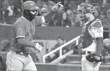  ?? Ed Zurga Getty Images ?? MIKE TROUT jogs past Kansas City catcher Drew Butera after hitting a home run, one of three by the Angels in wind chill temperatur­es in the 20s. Trout has four home runs in last seven games and six overall.