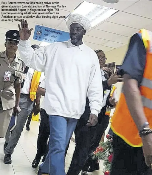  ??  ?? Buju Banton waves to fans on his arrival at the general aviation (private) section at Norman Manley Internatio­nal Airport in Kingston last night. The Grammy-winning artiste was released from an American prison yesterday after serving eight years on a drug charge.