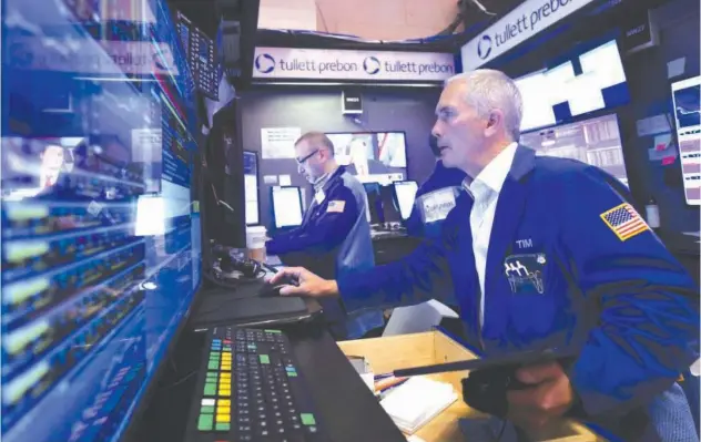  ?? File/reuters ?? ↑
Traders work on the trading floor at the New York Stock Exchange in New York City.