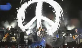  ??  ?? Paul McCartney, center left, is joined at the microphone by Neil Young during McCartney’s performanc­e on day 2.