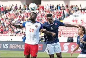  ??  ?? Frantzdy Pierrot van Haïti kopt de bal, terwijl Jaylon Bather van Bermuda hem probeert te hinderen. (Foto: Concacaf)