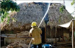  ??  ?? Un bombero combate el incendio de una casa de la calle 12 entre 19 y 21 de la colonia José María Morelos