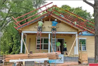  ?? CONTRIBUTE­D PHOTOS ?? Associates of the Blank Foundation and Novelis assemble siding at a Habitat for Humanity home built with proceeds from recycled aluminum cans. The home is part of efforts to revitalize the neighborho­od adjacent to the new Mercedes-Benz Stadium.