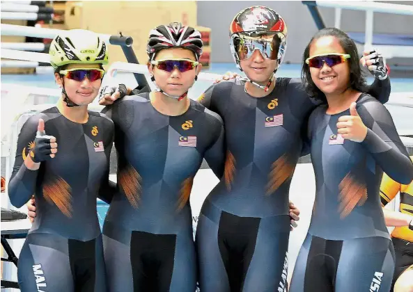  ??  ?? Ready to roll: National women track cyclists (from left) Jupha Somnet, Fatehah Mustapa, Anis Amira Rosidi and Farina Shawati Mohd Adnan giving the thumbs up before a training session at the National Velodrome in Nilai on Friday. — Bernama