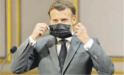  ?? Ludovic Marin / Reuters ?? El presidente francés, Emmanuel Macron, se coloca la mascarilla, el lunes, en el Elíseo.