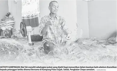  ?? — Gambar Bernama ?? AKTIVITI SAMPINGAN: Mat Yeh meneliti sebahagian pukat yang dijahit bagi memastikan dalam keadaan baik sebelum diserahkan kepada pelanggan ketika ditemui Bernama di Kampung Pulau Gajah, Sabak, Pengkalan Chepa semalam.