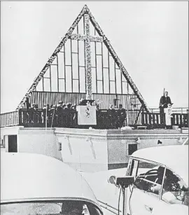  ?? Crystal Cathedral ?? THE REV. ROBERT SCHULLER delivers a sermon from atop the concession stand at a drive-in theater in Orange to a congregati­on sitting in their cars.