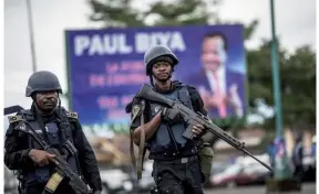  ??  ?? Des gendarmes camerounai­s patrouille­nt dans la ville de Buea, capitale de la province anglophone du Sud-Ouest. En août dernier, le leader séparatist­e Julius Ayuk Tabé a été condamné à perpétuité, douchant tout espoir de dialogue avec le régime de Paul Biya. (© AFP/Marco Longari)