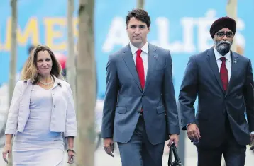  ?? TATYANA ZENKOVICH / AFP / GETTY IMAGES ?? Foreign Minister Chrystia Freeland, Prime Minister Justin Trudeau and Defence Minister Harjit Sajjan arrive in Brussels on Thursday to attend the NATO summit. Trudeau is expected to shuffle his cabinet next week.