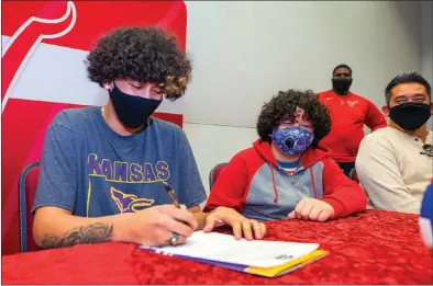  ?? STEVE MARCUS ?? Colin Salgado Lindo, left, a Valley High School graduate, signs a letter of intent to play volleyball for Kansas Wesleyan University on Wednesday at the Cambridge Recreation Center. At right are Salgado’s brother Giancarlo, 12, and his father, Edgard Salgado.