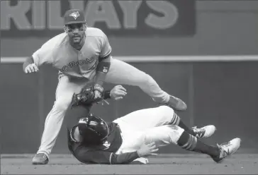  ?? Associated Press photo ?? Toronto Blue Jays’ Devon Travis leaps over Milwaukee Brewers’ Eric Sogard to turn a double play on a ball hit by Keon Broxton during the fifth inning of a baseball game, Wednesday, in Milwaukee.