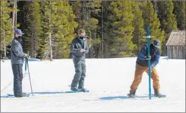  ?? Randall Benton Associated Press ?? JOHN PAASCH, left, Anthony Burdock and Sean de Guzman measure the Sierra snowpack for the Department of Water Resources. It was well below average.