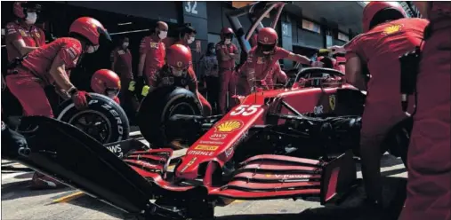  ??  ?? Carlos Sainz para en boxes a cambiar los neumáticos de su Ferrari SF21 durante los primeros entrenamie­ntos libres del GP de Gran Bretaña.