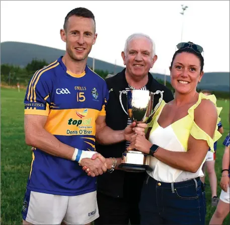  ??  ?? Ruth Allen, sponsor, and Johnny Brosnan, East Kerry Board Chairman, presenting the Tim Lenihan Memorial Cup at the East Kerry Junior League in Rathbeg Rathmore on Thursday to Glenflesk captain Jerry Kennedy Photo by Michelle Cooper Galvin