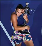  ?? Ng Han Guan / Associated Press ?? Aryna Sabalenka hugs the Daphne Akhurst Memorial Trophy after defeating Elena Rybakina in the women’s singles final at the Australian Open on Saturday.