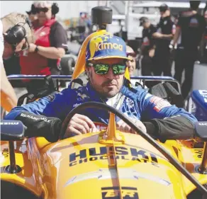  ?? Michael Conroy/The Associated Press ?? Fernando Alonso climbs into his car during practice for the Indy 500 at Indianapol­is Motor Speedway on Wednesday. He ended up crashing while exiting the third turn.