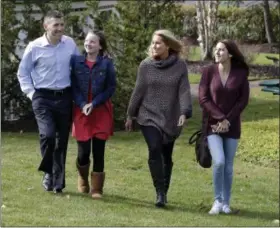  ?? RICHARD DREW — THE ASSOCIATED PRESS ?? From left, Peter Foster; adopted daughter; Kerry, 12; his wife, Susan, and their biological daughter, Emma, 17, walk on the grounds outside St. Barnabas Hospital, in Livingston, N.J., Tuesday. More than 15 years ago, 17 babies, including Emma, were...