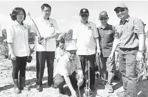  ??  ?? SIMBOLIK: Romie (duduk) menanam anak pokok bakau spesies kurap sebagai penyempurn­aan simbolik penanaman pokok paya bakau di Taman Negara Kuching Wetland, Tapak Ramsar, Kuching, semalam. Turut kelihatan Hamden (kanan) dan Claudius (tiga kanan).