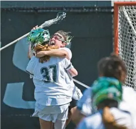  ?? KENNETH K. LAM/BALTIMORE SUN ?? Loyola Maryland goalkeeper Lauren Spence hugs Katie Detwiler to celebrate a 9-8 victory over Stony Brook in an NCAA Tournament second-round game on Sunday at Ridley Athletic Complex.