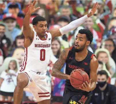  ?? MARY LANGENFELD / USA TODAY SPORTS ?? Maryland guard Eric Ayala looks to pass as UW guard D'Mitrik Trice defends.