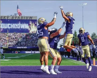  ?? DEAN RUTZ/SEATTLE TIMES/TNS ?? Washington wide receiver Jalen Mcmillan gets high celebratin­g his 19-yard touchdown run against Boise State as the Huskies continued last season’s winning run with a 56-19 romp.