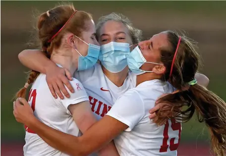  ?? MATT sTONE / HErAld sTAff filE ?? BACK OFF A BIG YEAR: Hingham’s Claire Murray, left, and Alexa Varholak, right, hug Sophie Reale after she scored against Whitman-Hanson on Nov. 6, 2020.