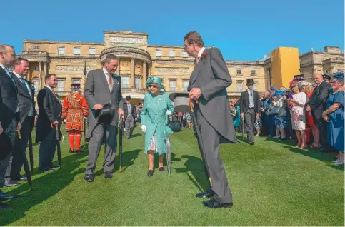  ??  ?? La reine Élisabeth II lors de l’une des traditionn­elles garden-parties organisées dans les splendides jardins du palais pendant la belle saison. La reine convie chaque année 30000 invités à y assister. Cette tradition initiée par la reine Victoria remonte aux années 1860.