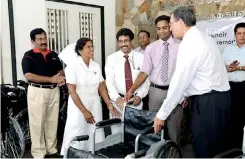  ??  ?? The wheelchair­s being handed over by Royle Jansz - Chairman, DFCC Bank.