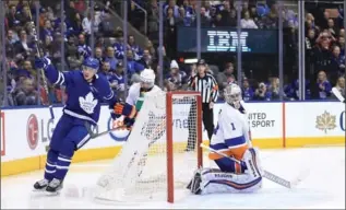  ?? RENÉ JOHNSTON, TORONTO STAR ?? New York Islanders goalie Thomas Greiss looks to his net as Maple Leafs’ Justin Holl celebrates his first goal in his first National Hockey League game in the third period Wednesday night in Toronto.