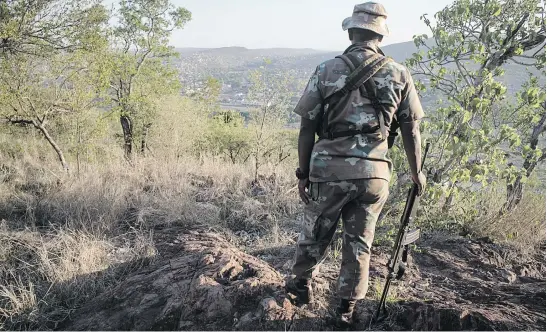  ?? Picture: Jacques Nelles ?? VANTAGE POINT. A soldier from the SA Defence Force looks at the border crossing into Mozambique. From this hill, soldiers can see illegal border crossings and react quickly.
