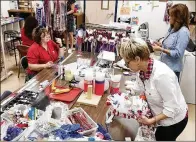  ?? ED ALLEN / WESTLAKE ?? Sarah Benton (clockwise from left) Kathy Elswick and Shery Dollihite prepare lifelike mum arrangemen­ts as part of the 17th annual Westlake High School Homecoming mums fundraiser for the PTO.