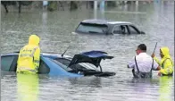  ?? HE JUNYI / FOR CHINA DAILY ?? Workers check flooded cars in Guiyang, Guizhou province, on Monday following heavy rains. South China is being affected by weather associated with Typhoon Merbok.