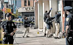  ?? JEENAH MOON/AP ?? Police investigat­e the scene of an attack Saturday in Manhattan’s Chinatown area.