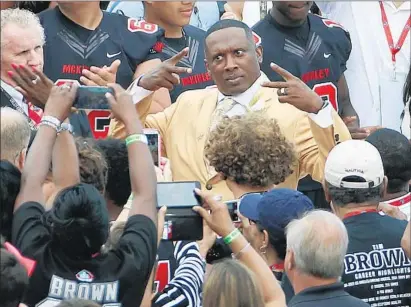  ?? Gene J. Puskar
Associated Press ?? TIM BROWN SEEMS to be enjoying himself as he poses with fans while wearing his new gold Hall of Fame jacket.