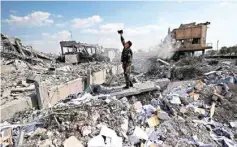  ??  ?? A Syrian soldier films the damage of the Syrian Scientific Research Center which was attacked by US, British and French military strikes to punish President Bashar Assad for suspected chemical attack against civilians, in Barzeh, near Damascus, Syria,...