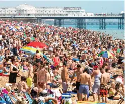  ??  ?? Anyone pack the suncream? Thousands hit Brighton beach