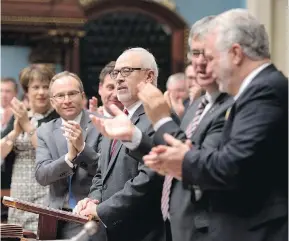  ?? JACQUES BOISSINOT/THE CANADIAN PRESS ?? Quebec Finance Minister Carlos Leitão, centre, presents his budget last year: It’s well known in Quebec that overall, the province is among the most heavily taxed jurisdicti­ons in North America. But its tax burden is not evenly distribute­d, Don...