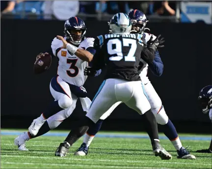  ?? ANDY CROSS — THE DENVER POST ?? Denver Broncos quarterbac­k Russell Wilson (3) scrambles out of the pocket as Denver Broncos offensive tackle Calvin Anderson blocks Carolina Panthers defensive end Yetur Gross-matos (97) in second quarter action at Bank of America Stadium in Charlotte, N.C., on Sunday.