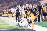  ?? Matthew Putney / Associated Press ?? Iowa wide receiver Nico Ragaini (89) dives to score a touchdown in front of Penn State safety Ji'Ayir Brown during the second half Saturday.