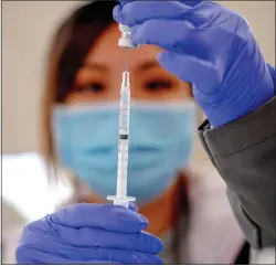  ?? WATCHARA PHOMICINDA, — SOUTHERN CALIFORNIA NEWS GROUP ?? IA registered nurse Hannah Fauni loads a syringe with the single-dose Janssen Covid-19vaccine by Johnson & Johnson as Riverside County made the new vaccine available to residents in Moreno Valley.