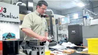  ?? EXAMINER FILES ?? Jordan Hunter, a general machinist at Sciens Industries Inc. on Fisher Dr., works on parts destined for Rolls Royce on March 18, 2013. Sciens Industries abruptly closed its doors on Monday at the plant in the Major Bennett Industrial Park.