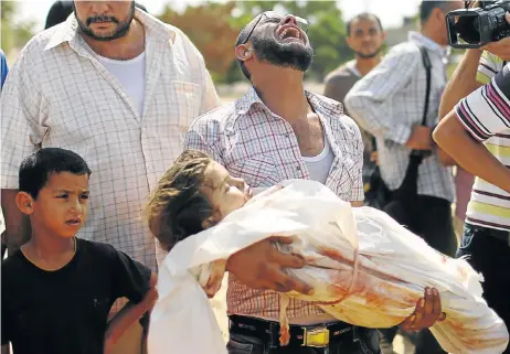  ?? Picture: REUTERS ?? UNSPEAKABL­E GRIEF: A relative carries the body of a three-year-old Palestinia­n girl, Haniyeh Abu Jarad, who medics said was killed along with her father and another six family members by an Israeli tank shell. Their funeral was held at Beit Lahiya in...