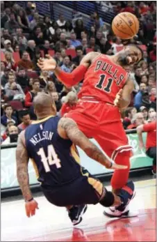  ?? DAVID BANKS — THE ASSOCIATED PRESS ?? Chicago’s David Nwaba (11) collides with New Orleans guard Jameer Nelson (14) of Chester during the second half Saturday in Chicago. The Pelicans won 96-90 in overtime.